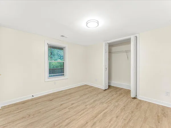 an empty room with wooden floor and window