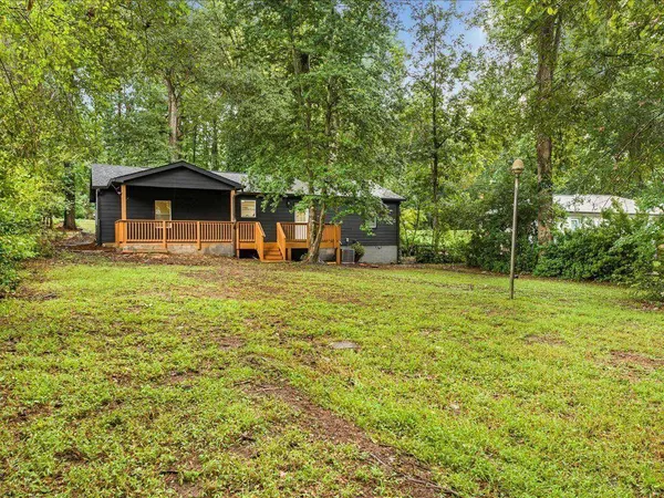 a view of a house with backyard and a tree