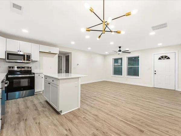 a kitchen with wooden floors and white appliances