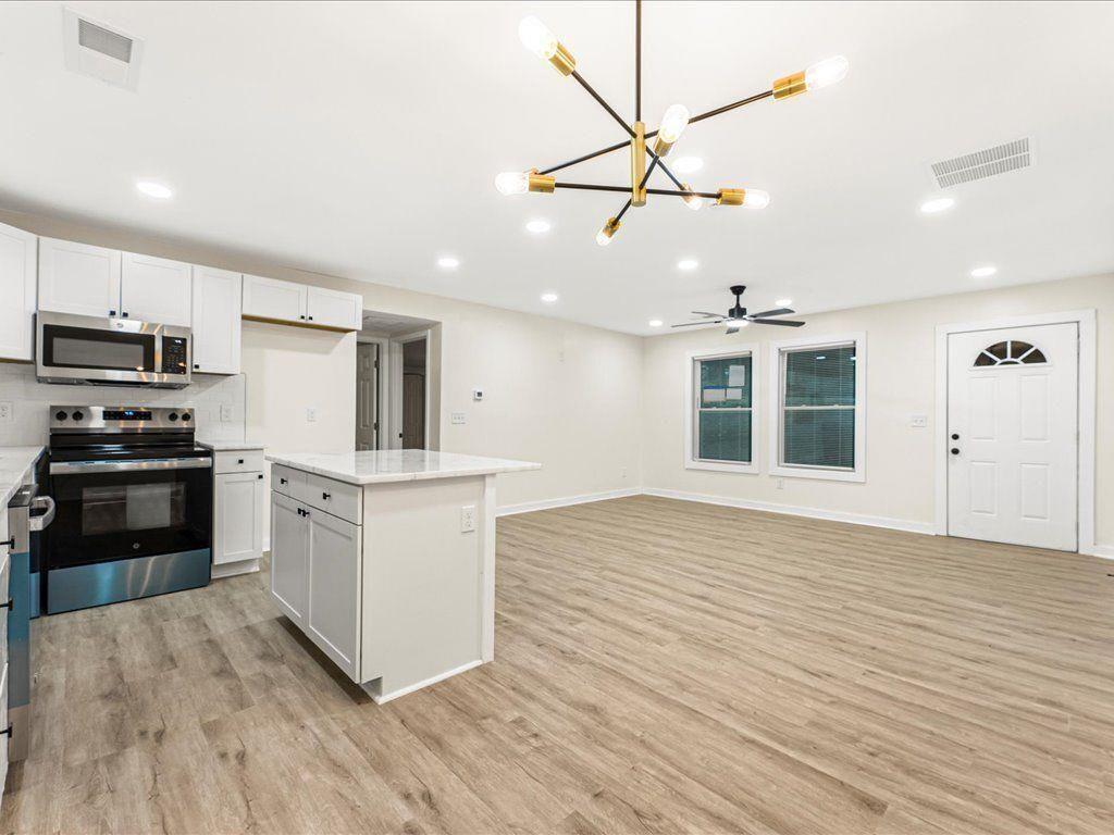 5794 Pinecrest Road Austell, GA 30168 - Photo 6 of 29 a kitchen with wooden floors and white appliances