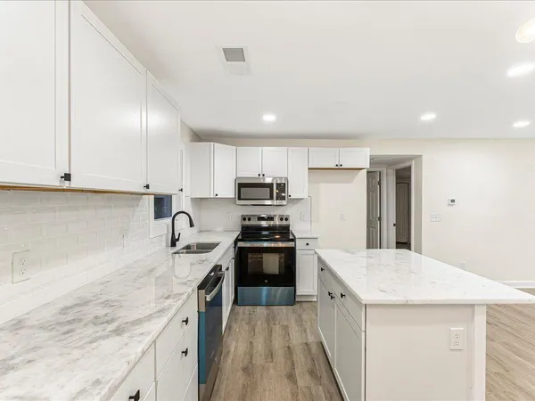 a kitchen with granite countertop stainless steel appliances and sink