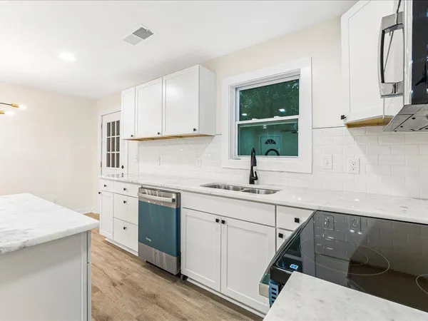 a kitchen with a sink stove and cabinets