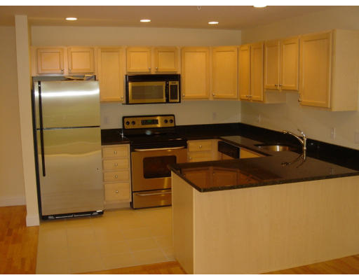 a kitchen with stainless steel appliances granite countertop a sink a stove and a refrigerator with wooden floor