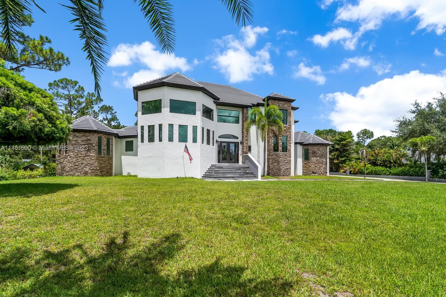 16189 Alexander Run Jupiter, FL 33478 - Photo 2 of 78 a front view of a house with garden
