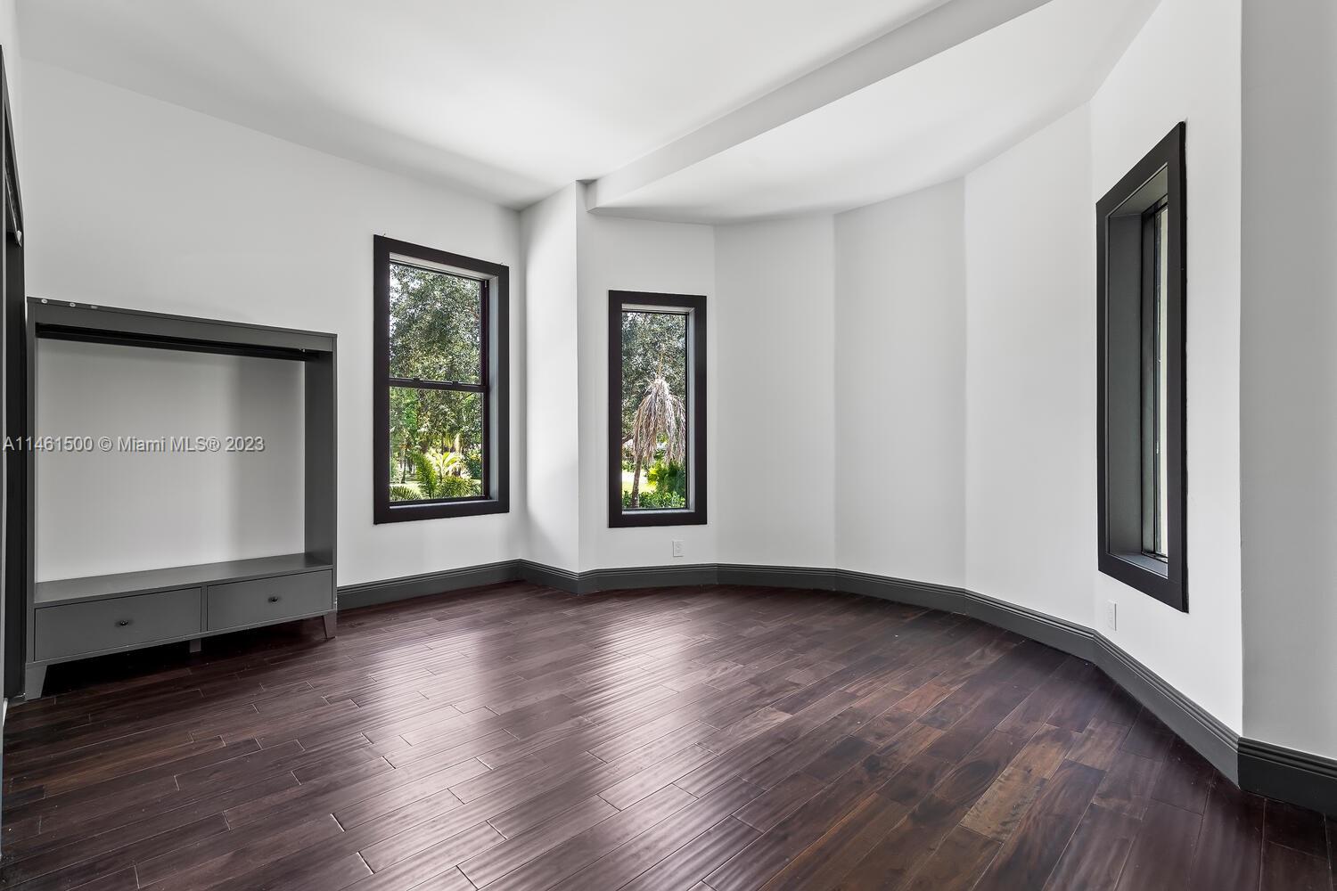16189 Alexander Run Jupiter, FL 33478 - Photo 25 of 78 a view of an empty room with wooden floor and a window