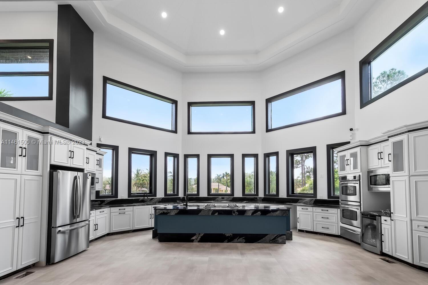 16189 Alexander Run Jupiter, FL 33478 - Photo 38 of 78 a large living room with stainless steel appliances kitchen island granite countertop furniture and a fireplace