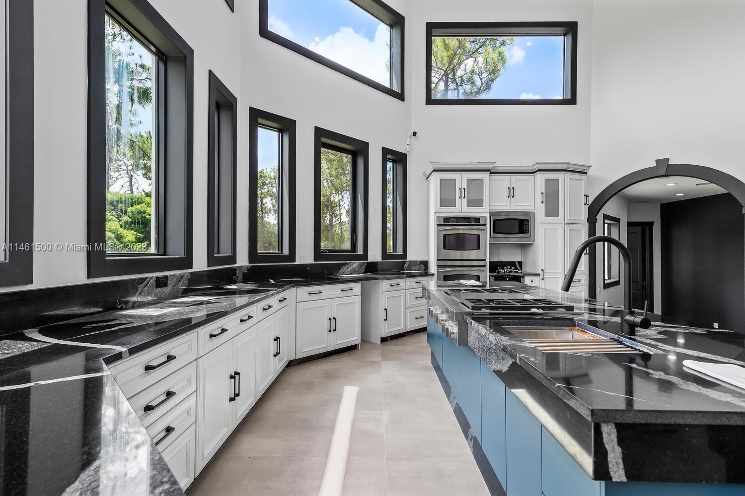 16189 Alexander Run Jupiter, FL 33478 - Photo 43 of 78 a kitchen with granite countertop a sink and a stove top oven