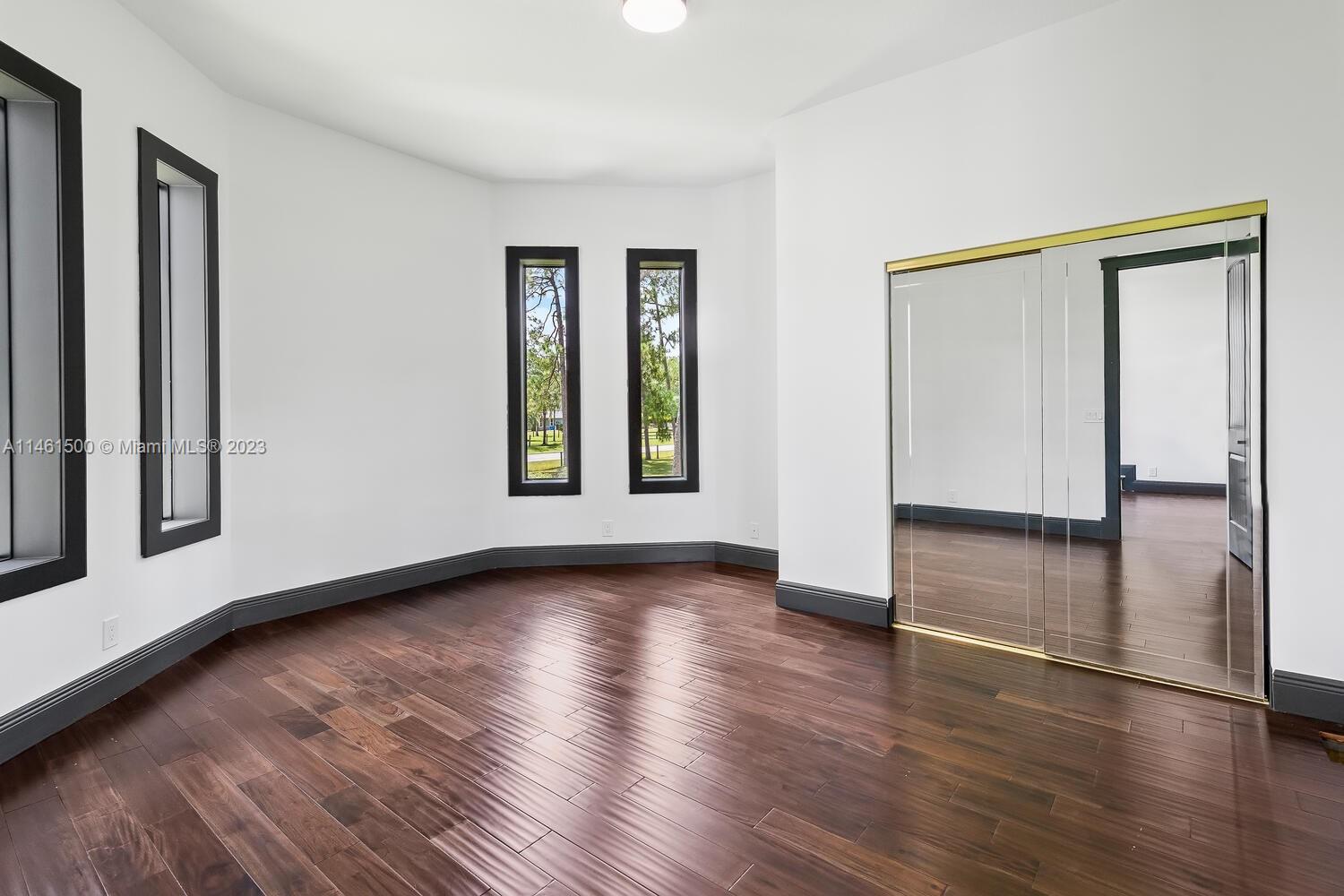 16189 Alexander Run Jupiter, FL 33478 - Photo 44 of 78 a view of an empty room with wooden floor and a window