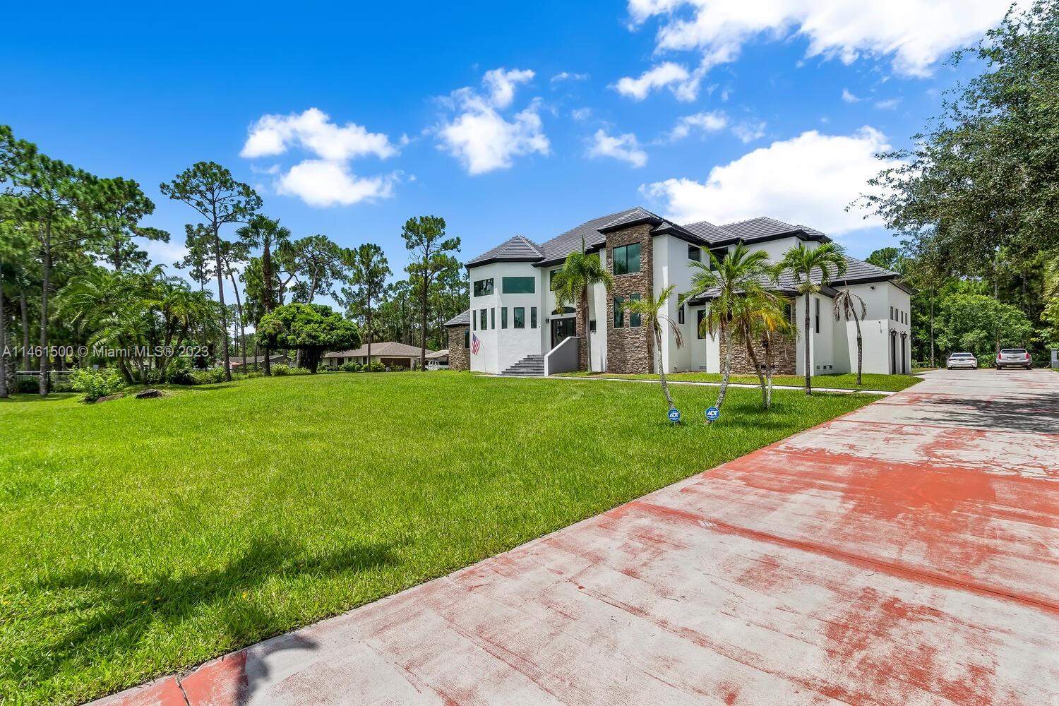 16189 Alexander Run Jupiter, FL 33478 - Photo 5 of 78 a front view of house with yard and green space