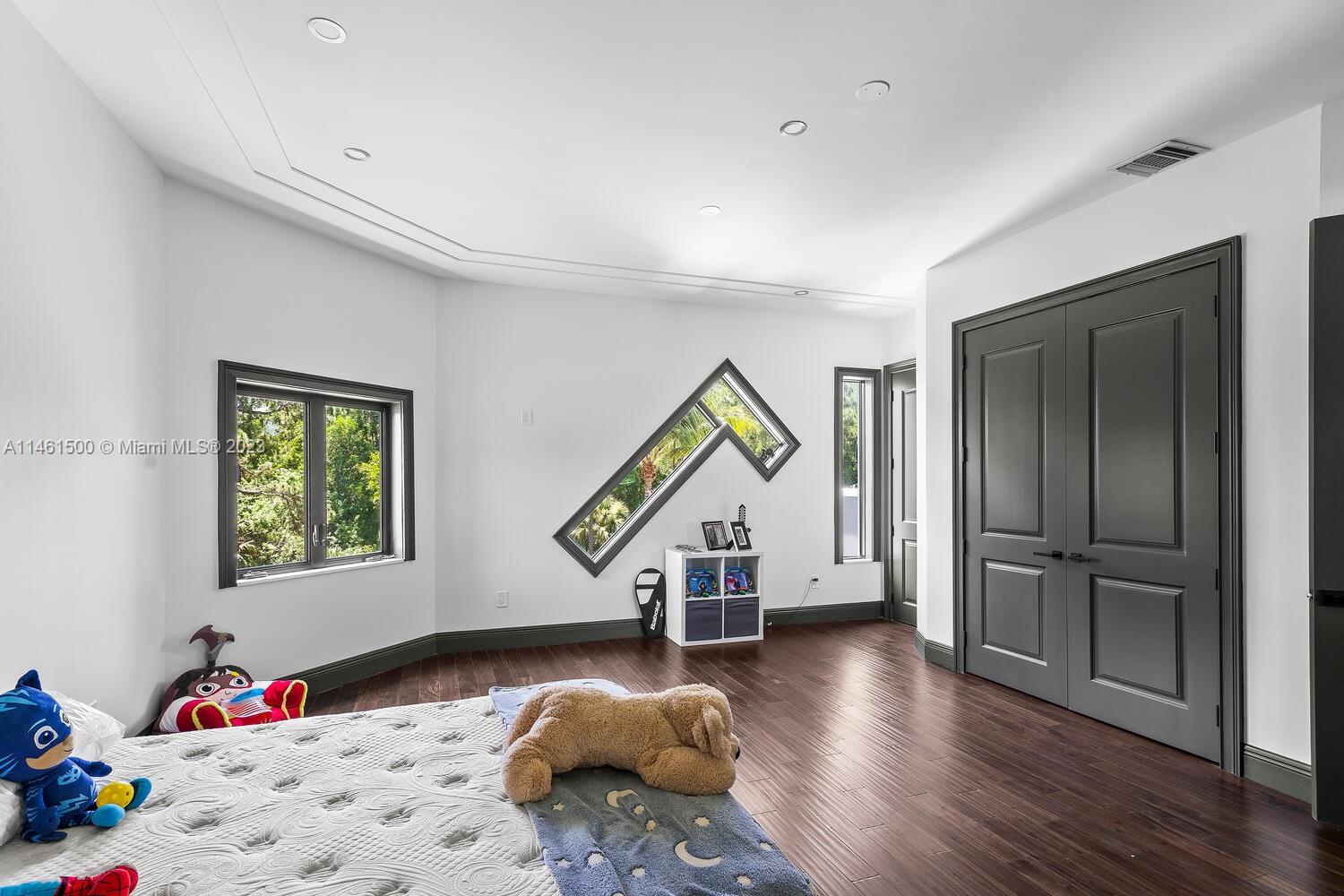 16189 Alexander Run Jupiter, FL 33478 - Photo 53 of 78 a bedroom with a bed and wooden floor