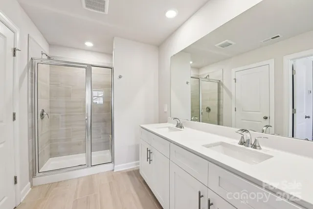 a spacious bathroom with a double vanity sink mirror and shower