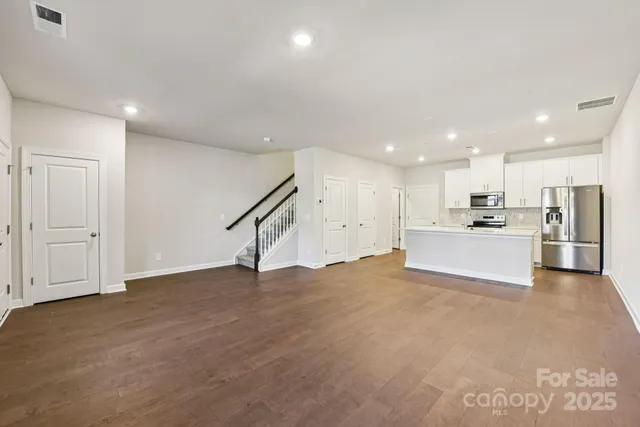 a view of an empty room with kitchen appliances and a window