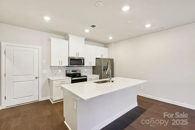 a kitchen that has a sink and a stove top oven