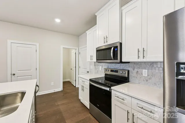 a kitchen with white cabinets and stainless steel appliances