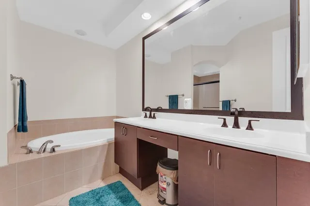 a bathroom with a tub sink and mirror