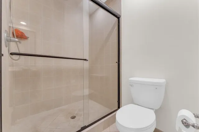 a white toilet sitting next to a shower
