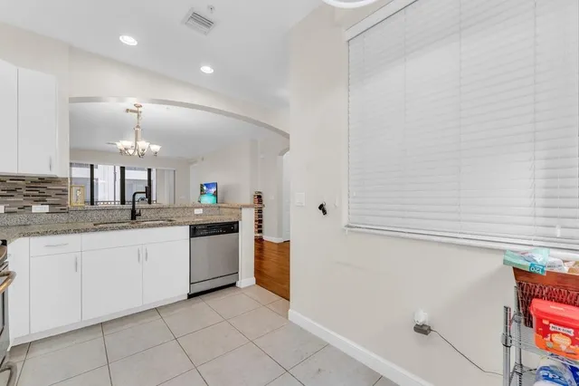 a large kitchen with granite countertop a white cabinets and a sink
