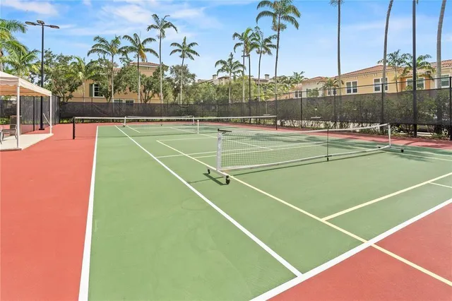 a view of a swimming pool with a yard and palm trees