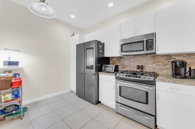 a kitchen with stainless steel appliances granite countertop a stove and a refrigerator