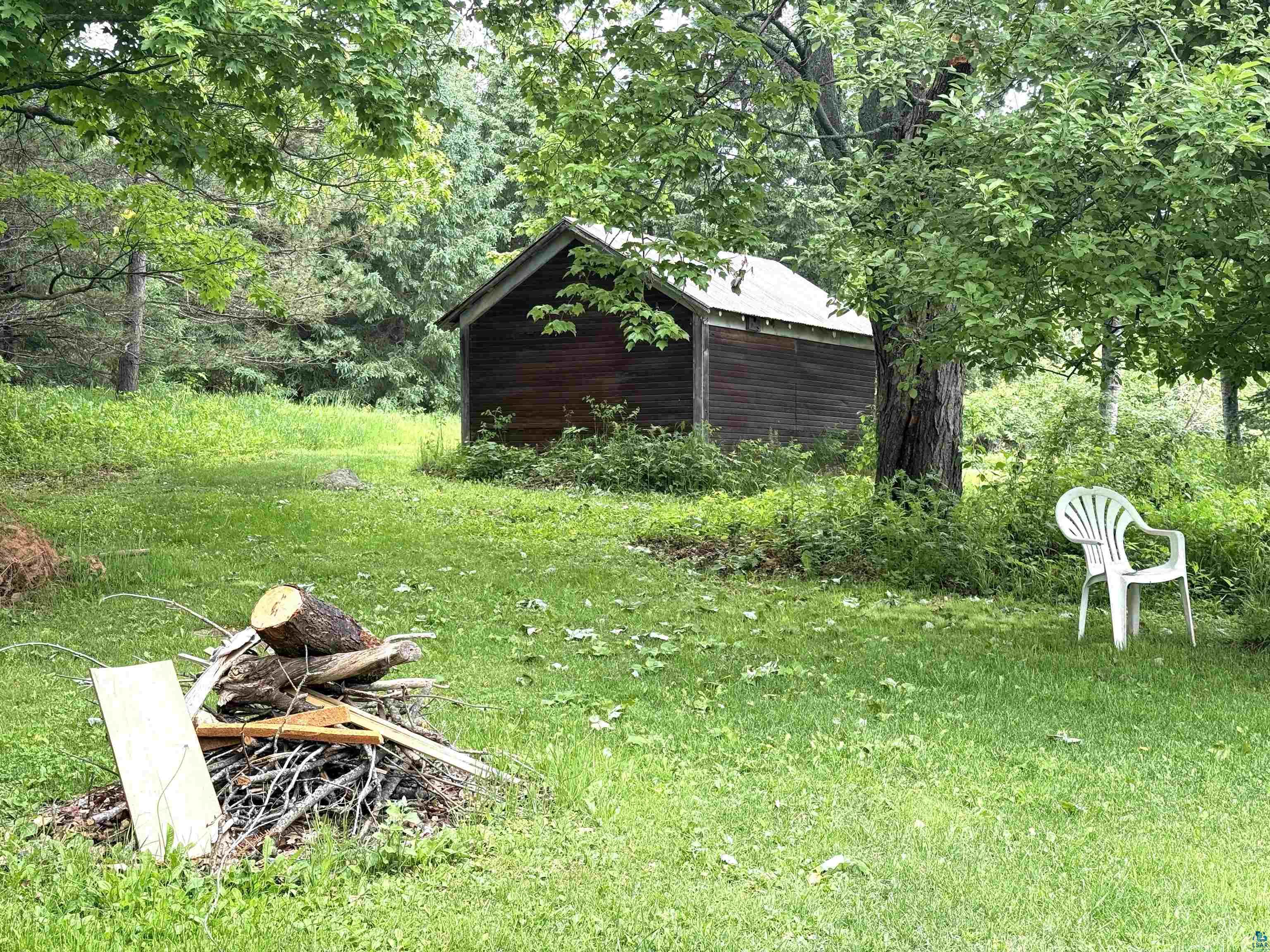 3541 Bent Trout Lake Road Barnum, MN 55707 - Photo 28 of 41 Wood-sided outbuilding with a metal roof, set amidst mature trees and a grassy yard