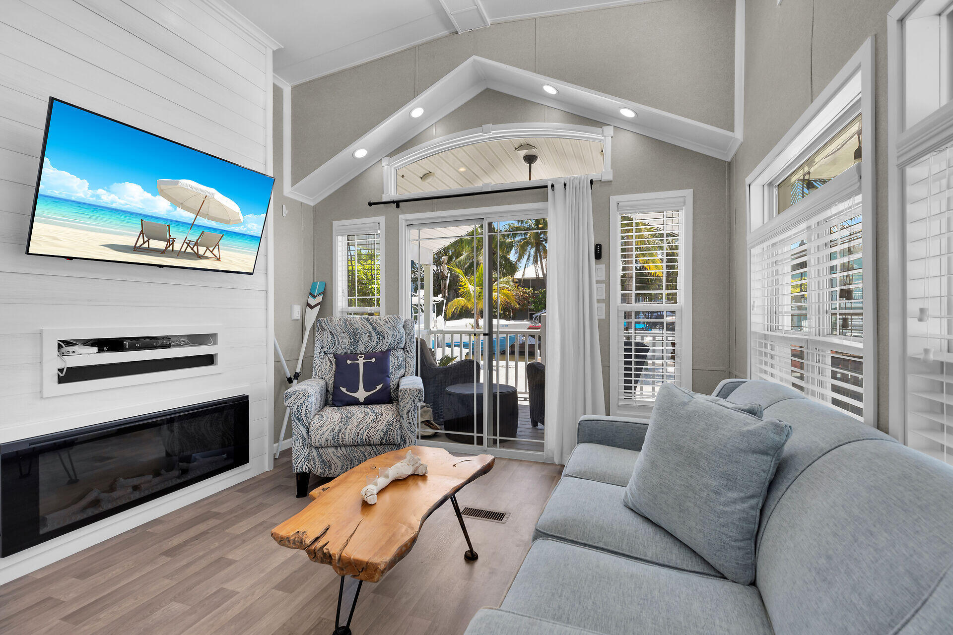 325 Calusa Street, Unit 250 Key Largo, FL 33037 - Photo 45 of 63 a living room with furniture a flat screen tv and a floor to ceiling window