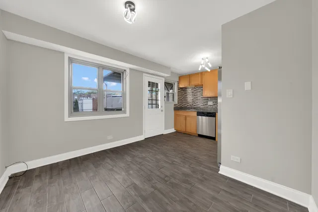 a view of a kitchen with wooden floor and a window
