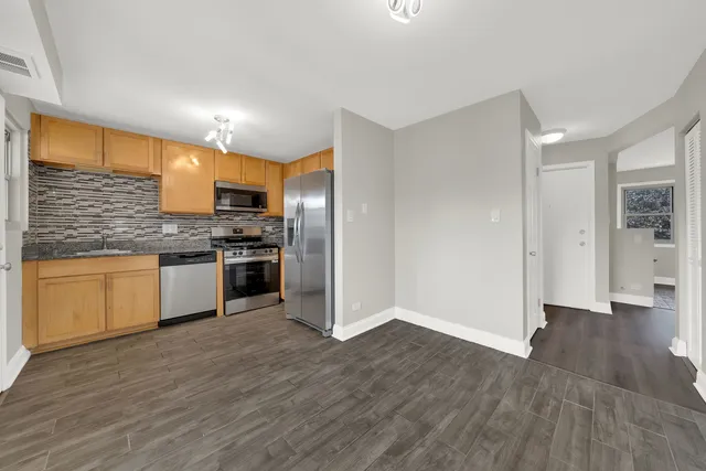 a kitchen with a refrigerator and a stove top oven