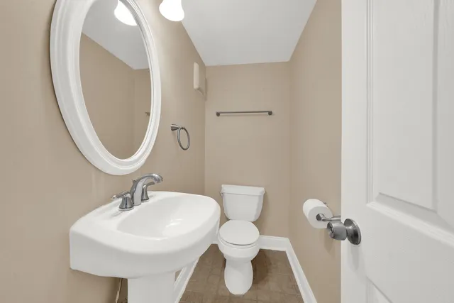 a bathroom with a sink toilet and a mirror