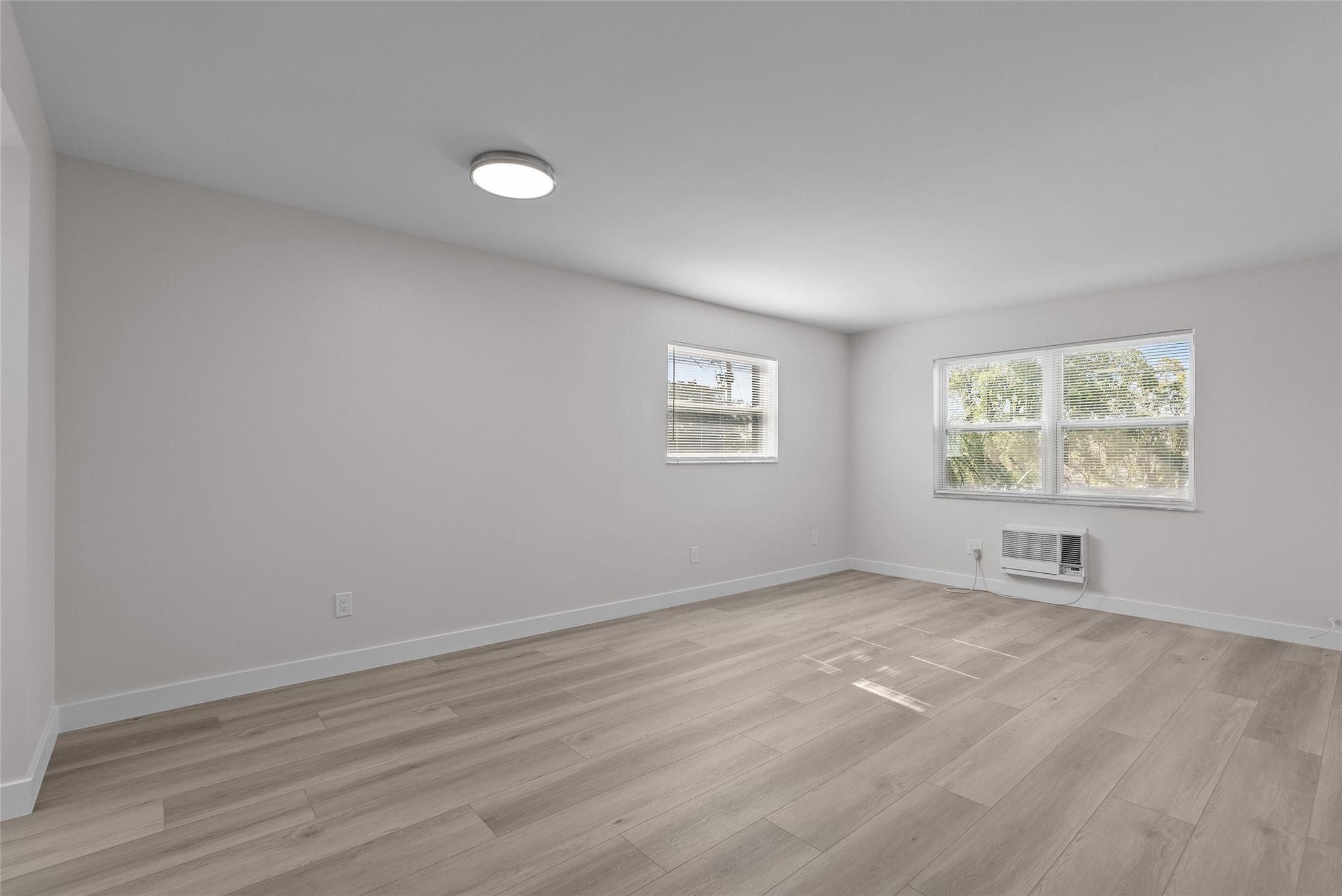 1150 East Sample Road, Unit 202 Pompano Beach, FL 33064 - Photo 6 of 20 an empty room with windows