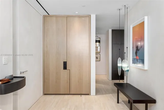 a view of a hallway with wooden floor and cabinet