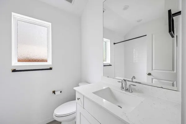 a bathroom with a sink a toilet and a mirror