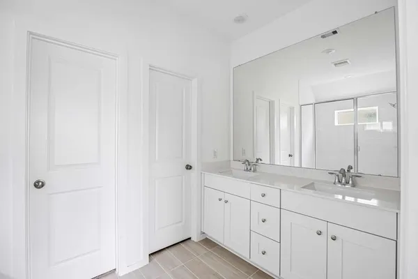 a bathroom with a double vanity sink and a mirror
