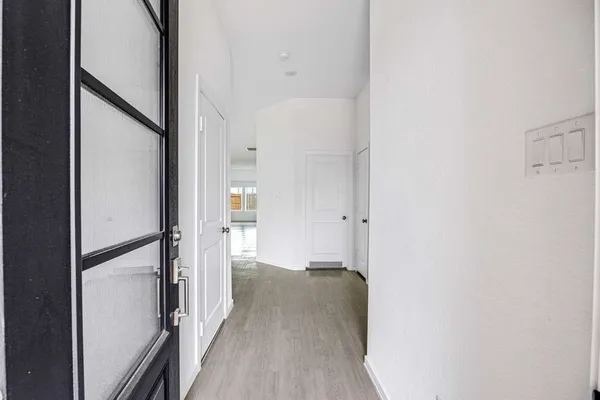 a view of a hallway with wooden floor and staircase
