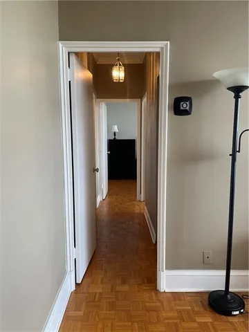 a view of a hallway with wooden floor and closet