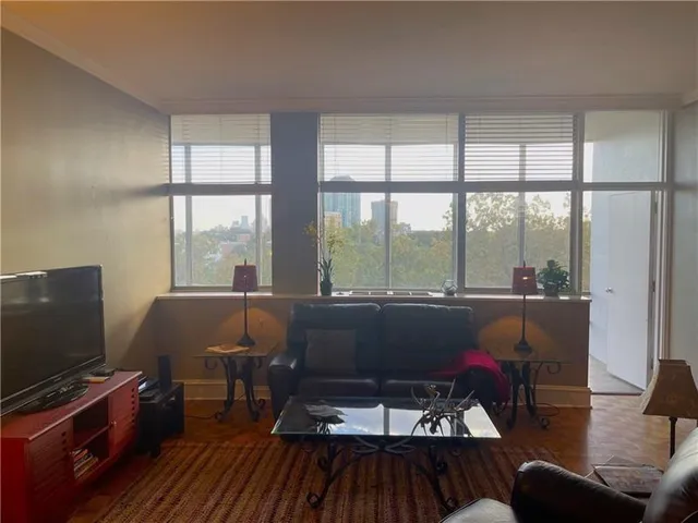 a living room with furniture and a flat screen tv next to a window