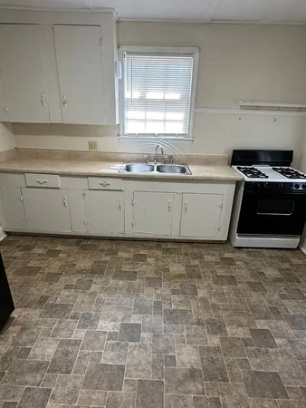 a view of a kitchen with granite countertop white cabinets and a stove