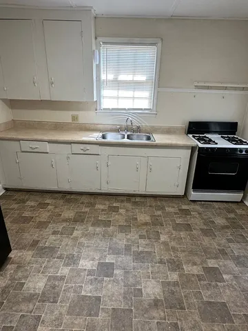 a view of a kitchen with granite countertop white cabinets and a stove