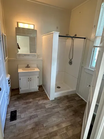 a bathroom with a sink a toilet a mirror and shower