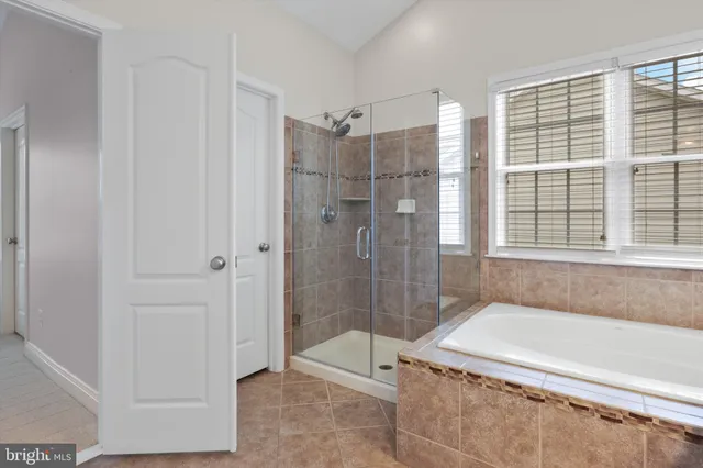 a bathroom with a granite countertop tub shower and sink