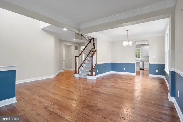 a view of a livingroom with wooden floor and stairs