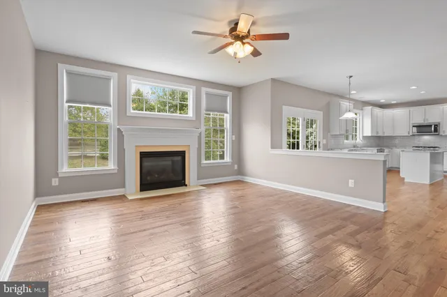 a view of an empty room with a window and fireplace