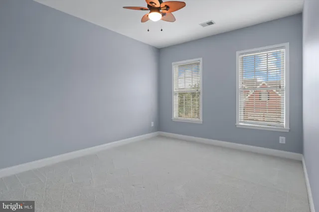 an empty room with a window and a fan
