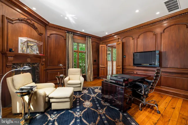 a living room with furniture a flat screen tv and floor to ceiling window