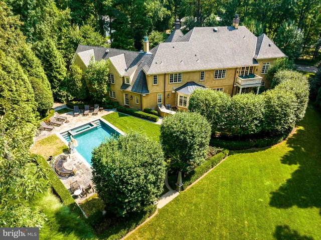 an aerial view of a house with swimming pool and garden