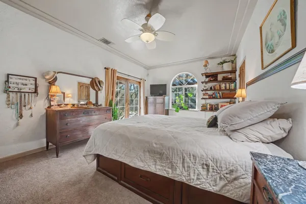 a bedroom with a large bed and a chandelier