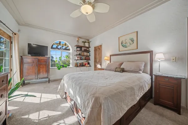 a bedroom with a bed mirror and a window