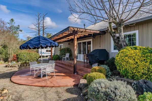 a patio with a table and chairs under an umbrella