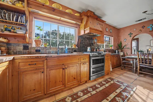 a kitchen with stainless steel appliances granite countertop a stove a sink and a microwave