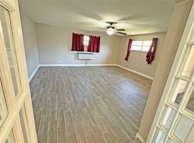 an empty room with windows and fan