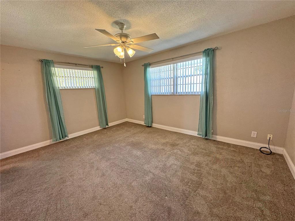 1421 Suwanee Road Daytona Beach, FL 32114 - Photo 12 of 21 an empty room with windows and fan